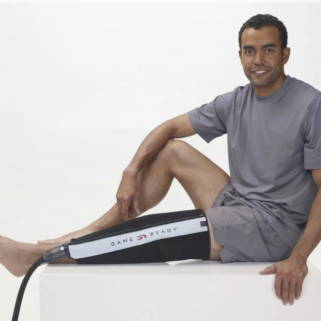 Uomo seduto con fascia Game Ready applicata al polpaccio destro per crioterapia e compressione