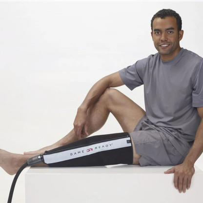 Uomo seduto con fascia Game Ready applicata al polpaccio destro per crioterapia e compressione